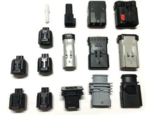 Assorted black and gray tuner harness plug connectors laid out in rows